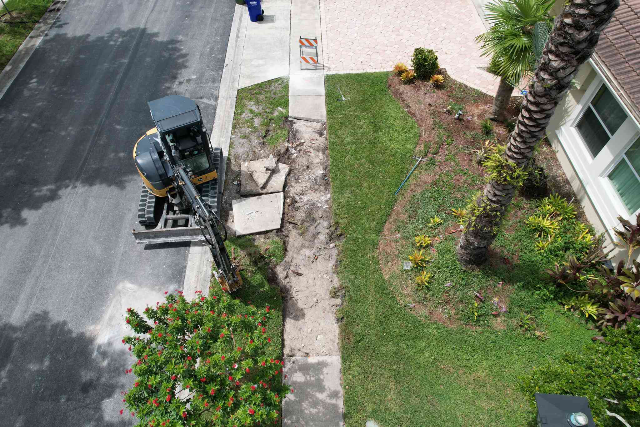 Concrete contractor 3-D Paving excavates an old sidewalk damaged by tree roots.