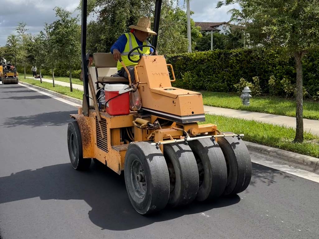 Asphalt paving in Sunrise Florida chooses 3-D Paving. 3-D Paving seen here with an asphalt rolling machine compacting a fresh lift of asphalt on a roadway in August of 2022.