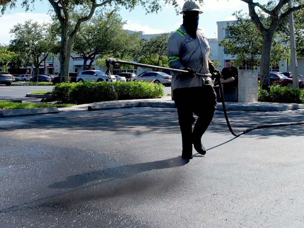 Asphalt preparation is key to a long-lasting and durable asphalt pavement. Seen here, a crew member from 3-D Paving spray a asphalt sealing coat known as "Sealcoating" the protects against the elements.
