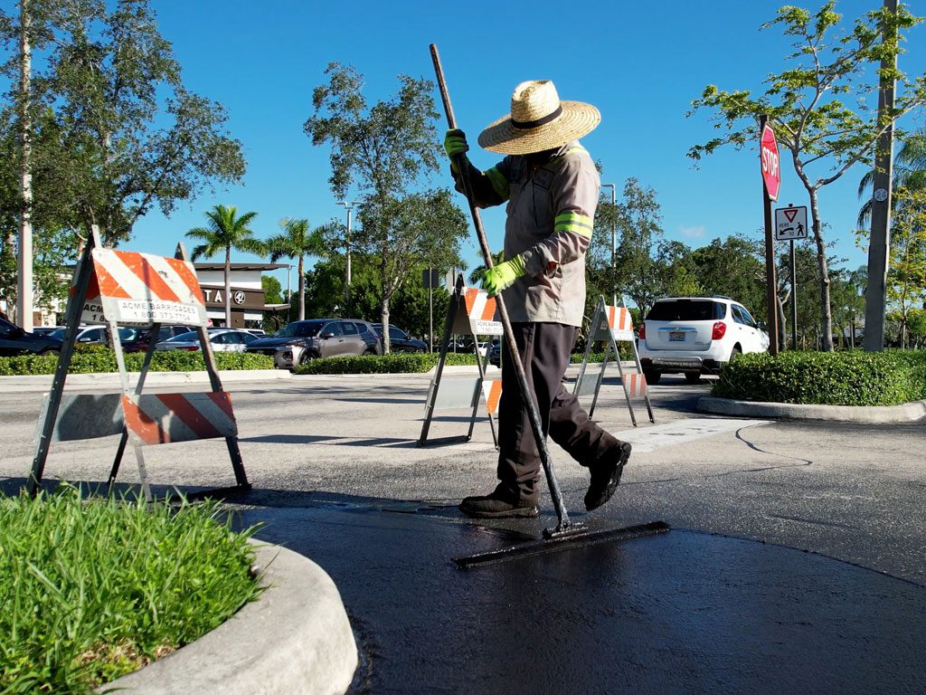 Sealcoating near me in the Fort Lauderdale area, 3-D Paving shown edging a large parking lot sealcoating job at the Tower Shops in Davie, Florida. Need asphalt in Hollywood FL? Need Sealcoating in Hollywood FL? Call the experts at 3-D Paving and Sealcoating