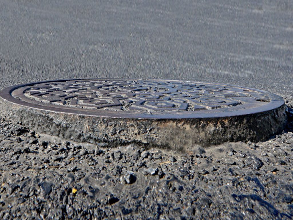 Raised or damaged manhole covers can cause major liabilities for property owners. Not only can a raised manhole cover create a hazard for pedestrians to trip and fall but they can also cause sever vehicle damage and traffic accidents. Contact South Florida's Pavement Experts 3-D Paving today.