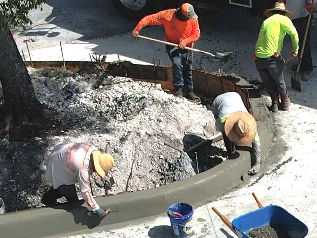 Concrete flatwork crew installs custom curbs into a new concrete parking lot