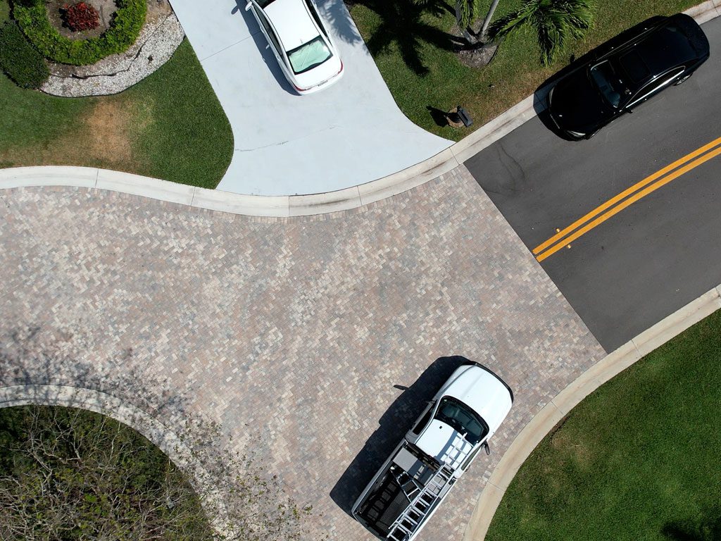 Paver brick, asphalt and concrete driveways intersect at a cul-de-sac freshly paved by 3-D Paving and Sealcoating in Coral Springs, FL.