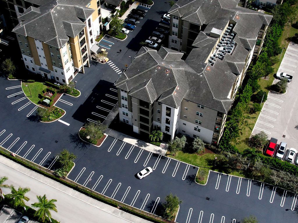 Aerial view of a South Florida Residential community Freshly paved, sealcoating & striped using vinyl striping at a parking lot in Coral Springs, FL by 3-D Paving and Sealcoating. South Florida's Commercial Paving Experts. April 2023.