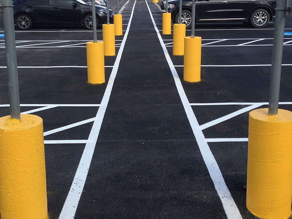 Parking lot bollards installed with signage on the top are a popular parking lot safety measure in south Florida.