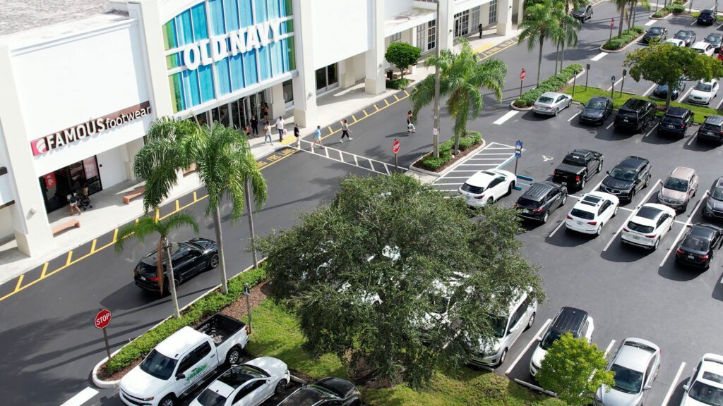 Drone photo of a newly renovated parking lot of an Old Navy retail store with cars and palm trees in Fort Lauderdale, FL. Need asphalt paving in Boca Raton? Call 3-D Paving today!