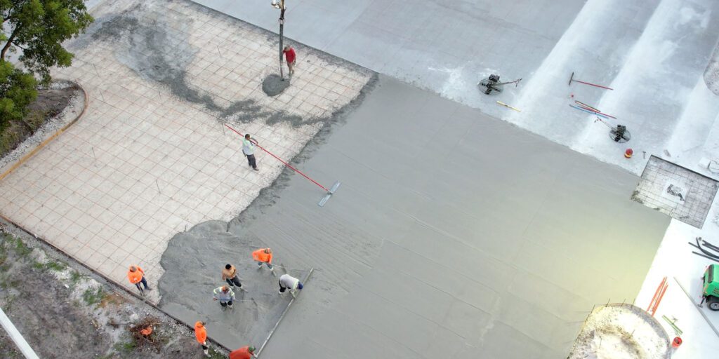 Concrete slabs being poured in sections pictured from an aerial view showing the process. Work done by 3-D Paving and Sealcoating. South Florida's pavement experts.