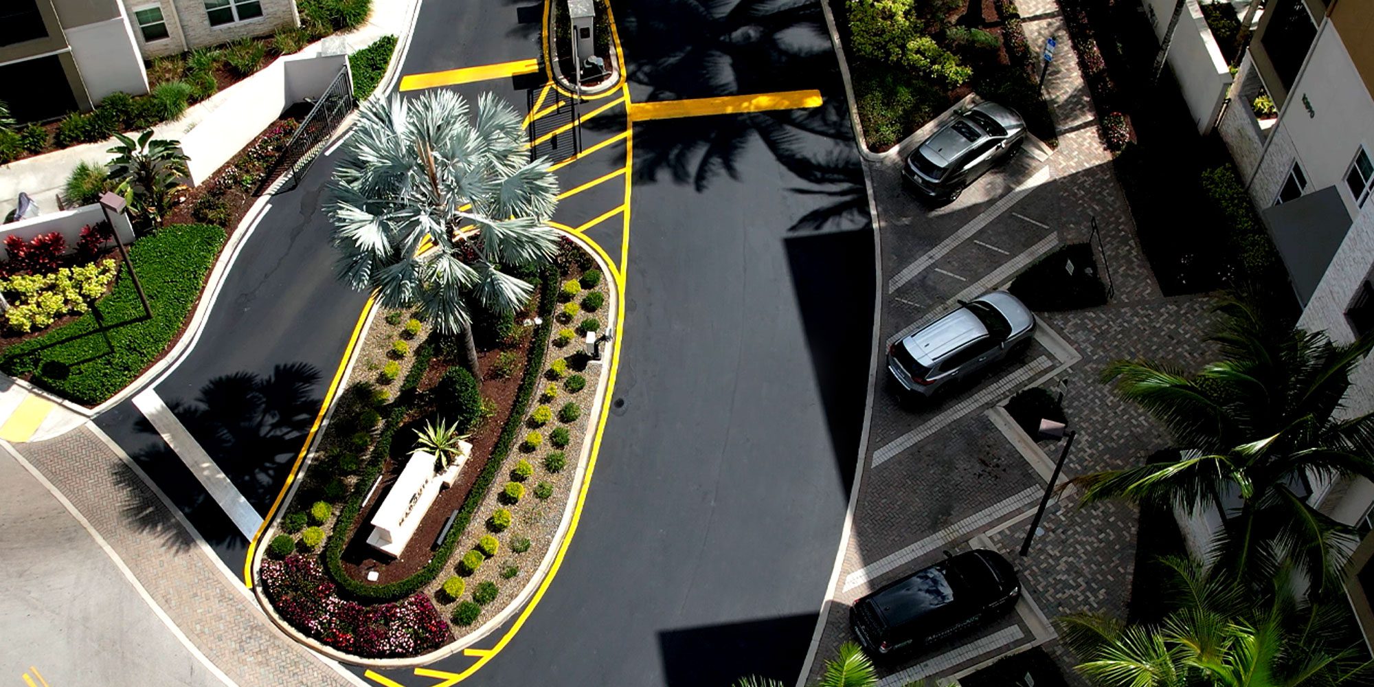 Aerial view of a South Florida HOA parking lot entryway that's beautifully landscaped with crosswalk, asphalt and concrete Freshly paved, sealcoating & striped using vinyl and thermoplastic striping at a country club gold course and attached condominium community in Coral Springs, FL by 3-D Paving and Sealcoating. South Florida's Premier Commercial Paving Contractor. April 2023. Considering an asphalt paving contract for 2023? Learn about asphalt paving systems in south florida from the experts at 3-D Paving and Sealcoating in Coral Springs, FL. 3-D Paving also serves West Palm Beach and greater Palm Beach, Florida. Need asphalt in Delray Beach? Are you looking for Sealcoating in Deray Beach? Call the experts at 3-D Paving and Sealcoating! Need asphalt or concrete in Coconut Creek? Look no further then 3-D Paving and Sealcoating. Asphalt Paving Sunrise Florida, Sealcoating Sunrise, FL. Asphalt paving in Naples, FL. Asphalt Paving Fort Myers.